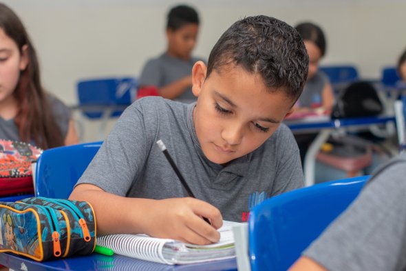 Foto de uma criança na sala de aula do IEMOL - Instituno Educacional Monteiro Lobato